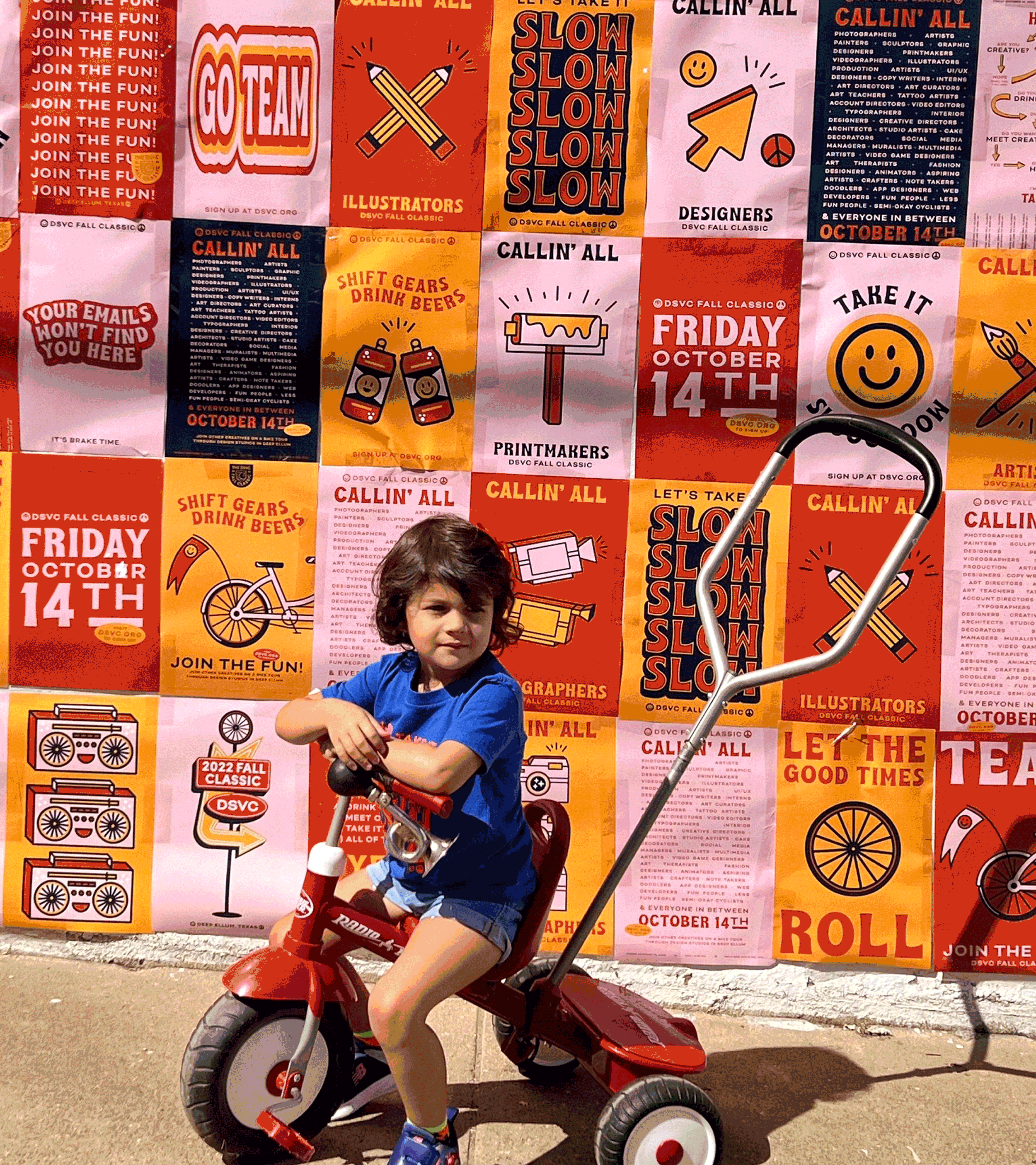 Image of a kid riding a bike in front of the event posters.