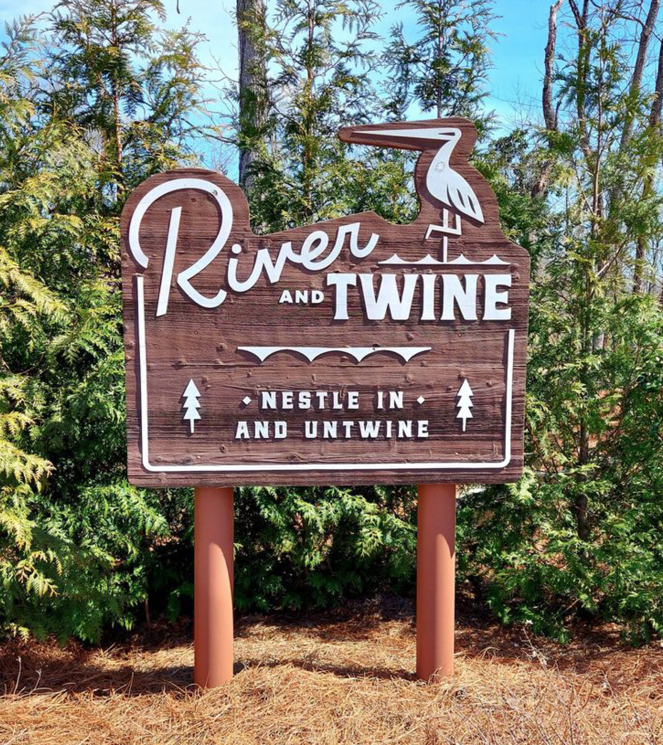 Rocky Mount River and Twine wooden outdoor signage of logo and "nestle in and untwine tagline"