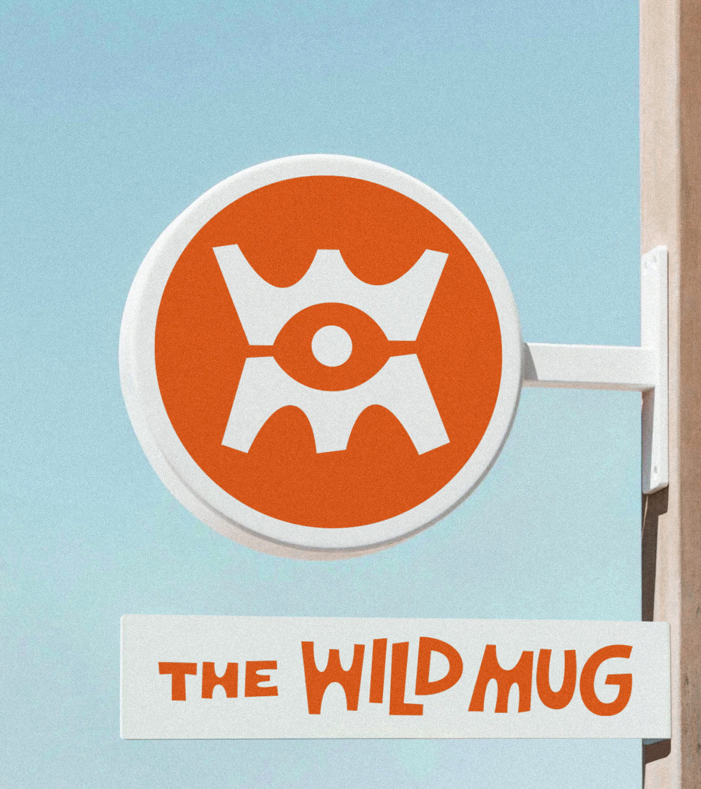 The Wild Mug building signage with WM eye monogram and wordmark in orange